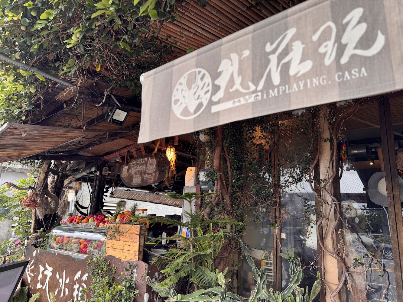 門口滿是植物與新鮮水果的飲品店櫃檯