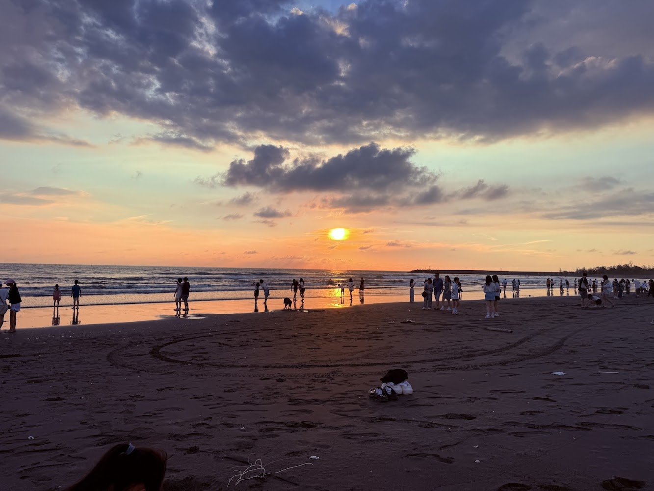 月牙灣夕陽時分，許多人在沙灘上散步欣賞海景