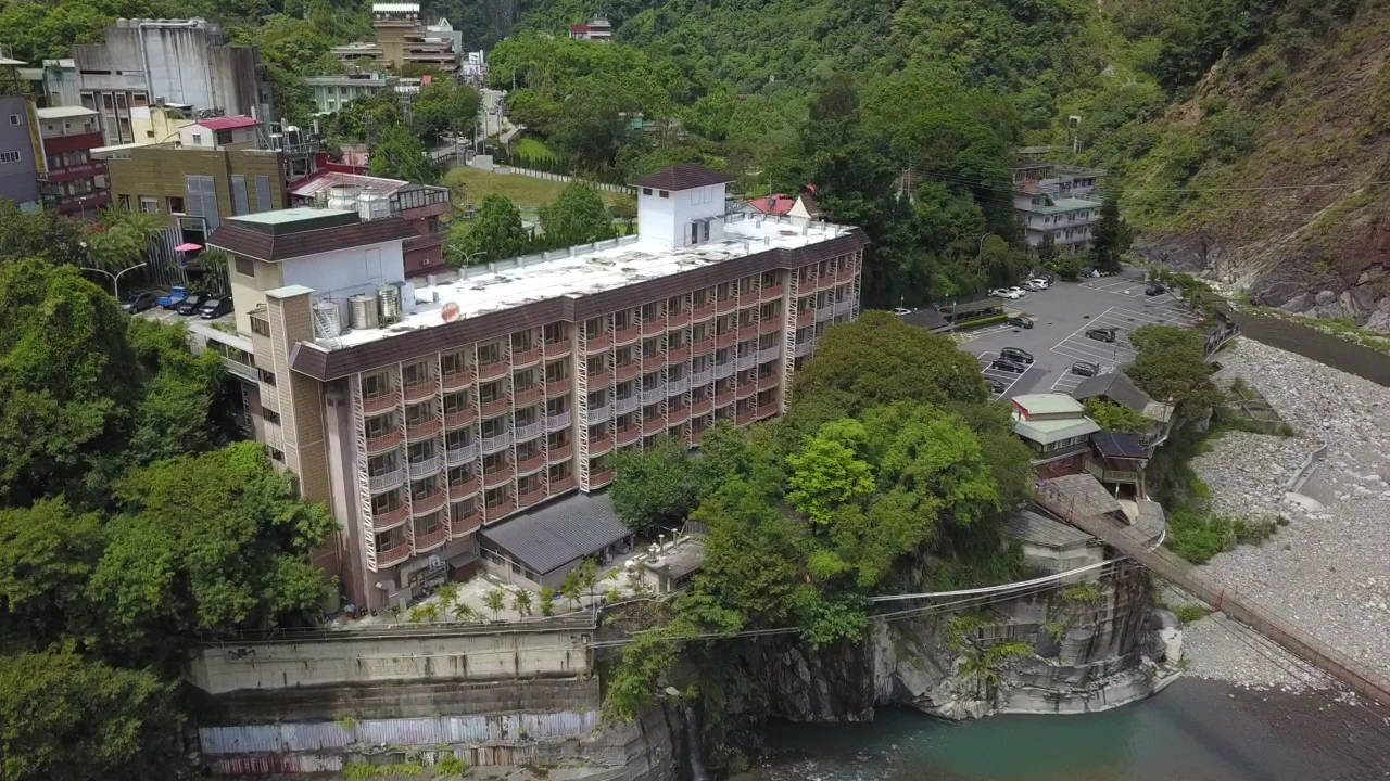 谷關河岸旁多層建築與清澈溪流