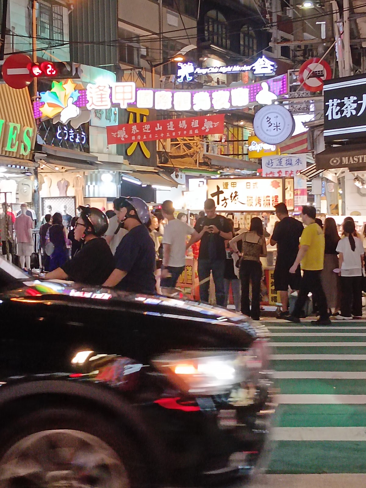 夜晚逢甲夜市入口彩色霓虹招牌人潮車輛交會台中夜市必遊