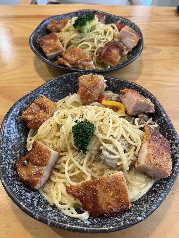 兩盤奶油義大利麵搭配煎得金黃的雞腿肉與蔬菜點綴