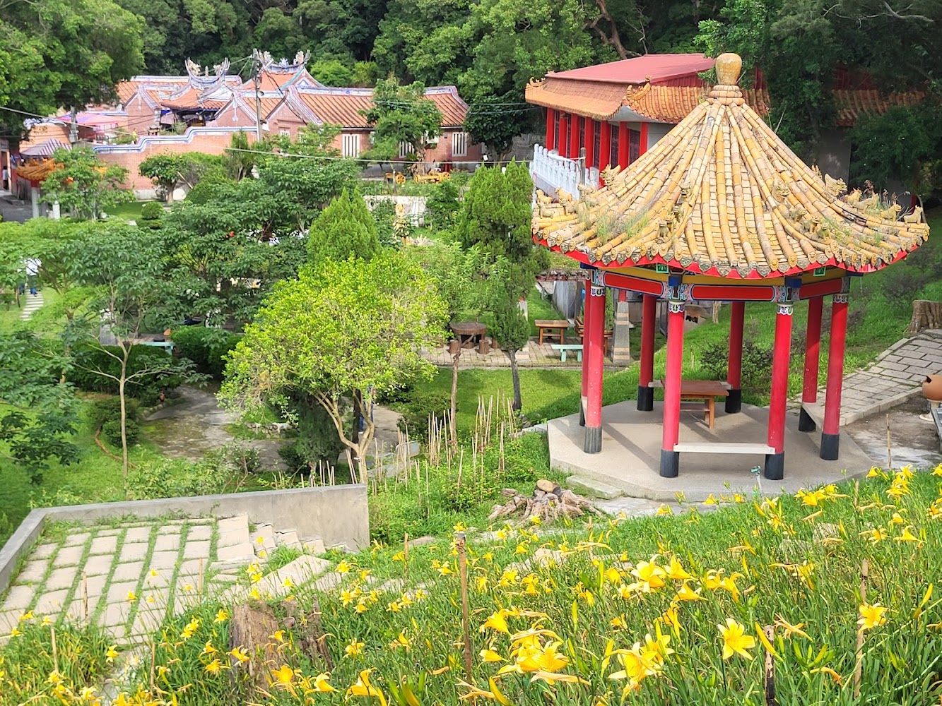 中國傳統六角涼亭，周邊有綠樹花卉和步道