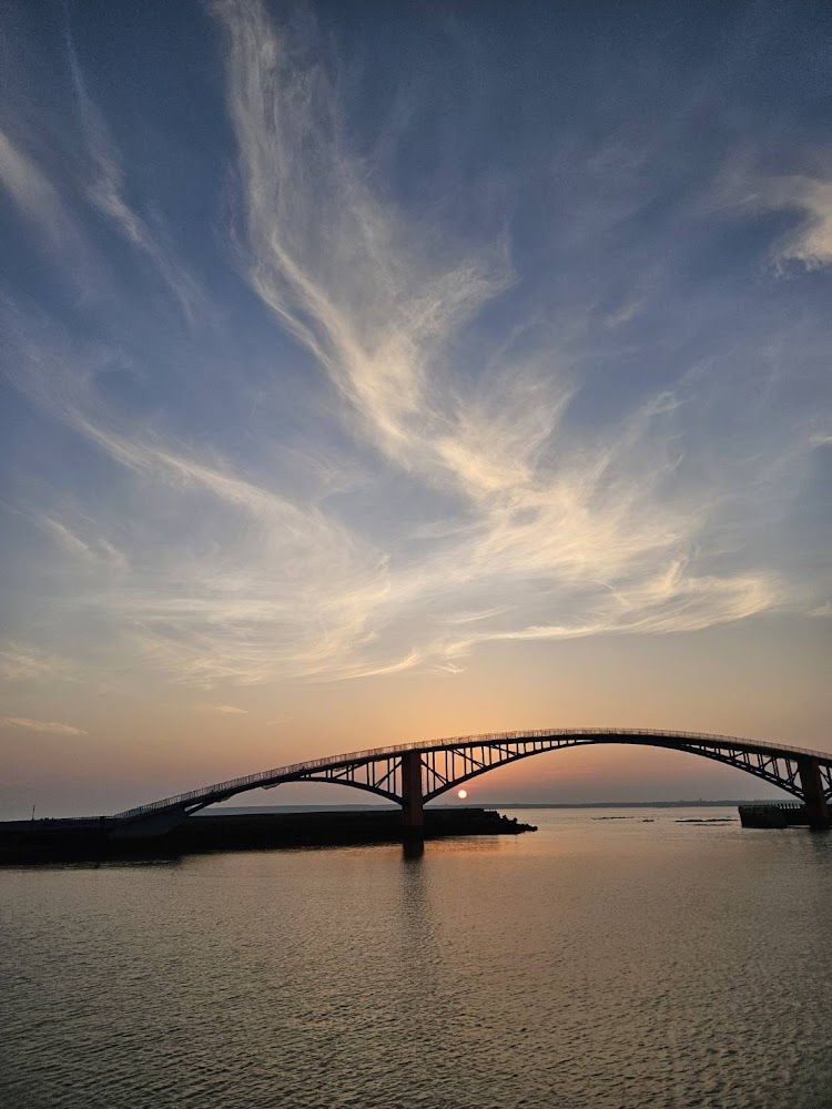 夕陽下的拱橋與海面景色