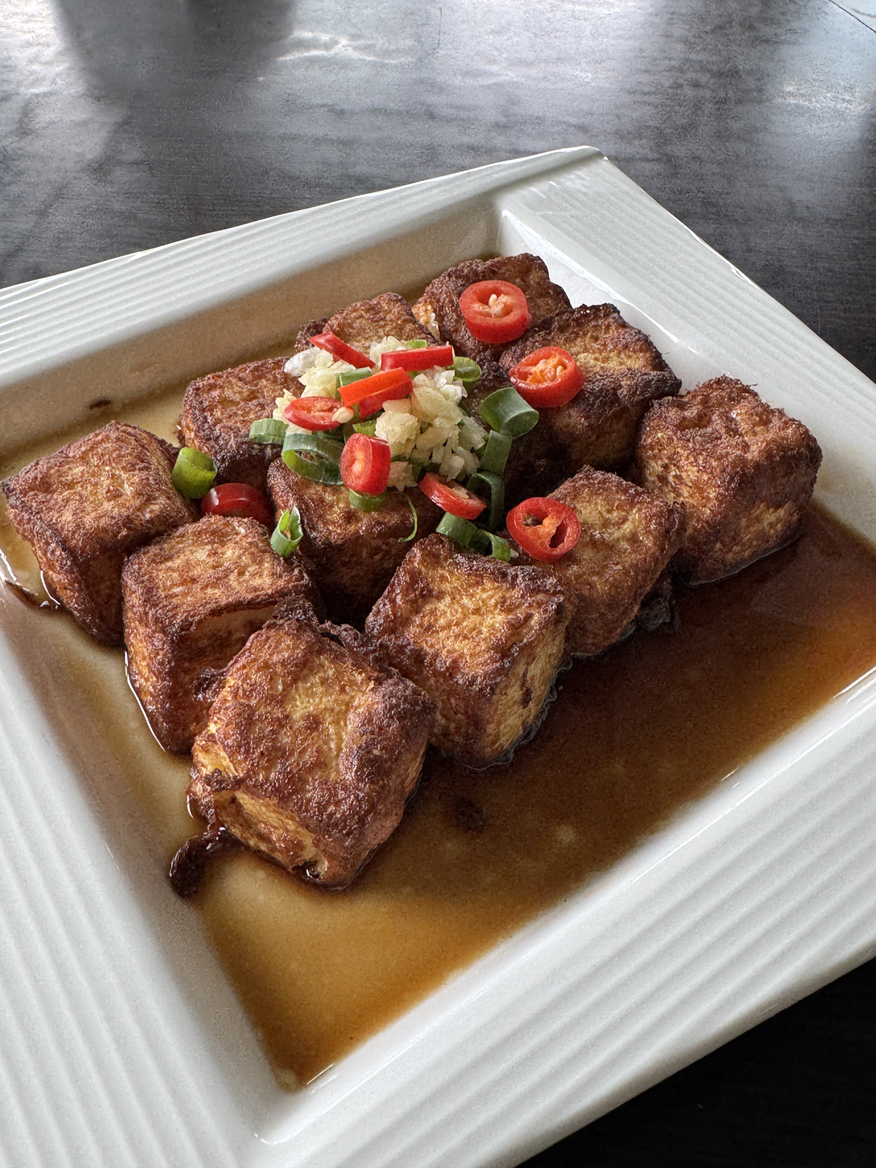 金黃酥脆炸豆腐，撒上蔥花與辣椒