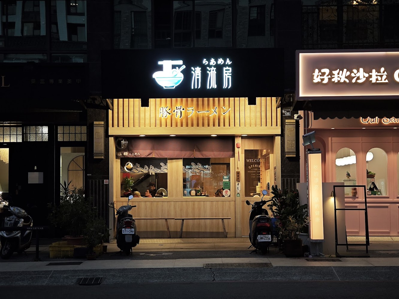 清流房日式拉麵夜間門口景象，外面停有機車，店內有客人用餐