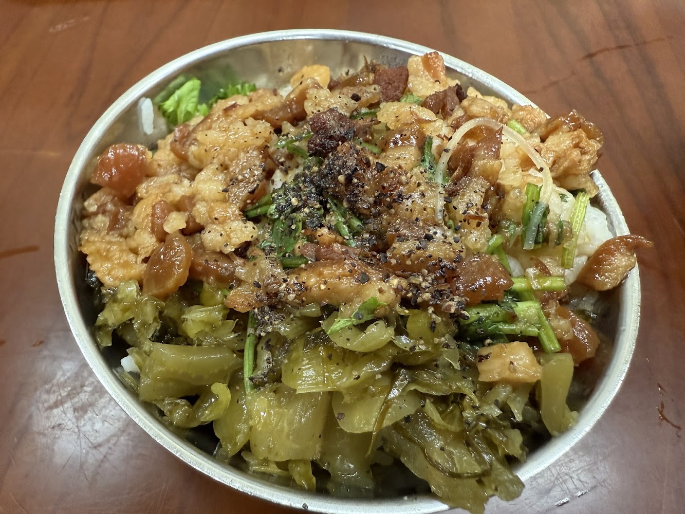 滷肉飯上面有滷肉香菜酸菜與胡椒