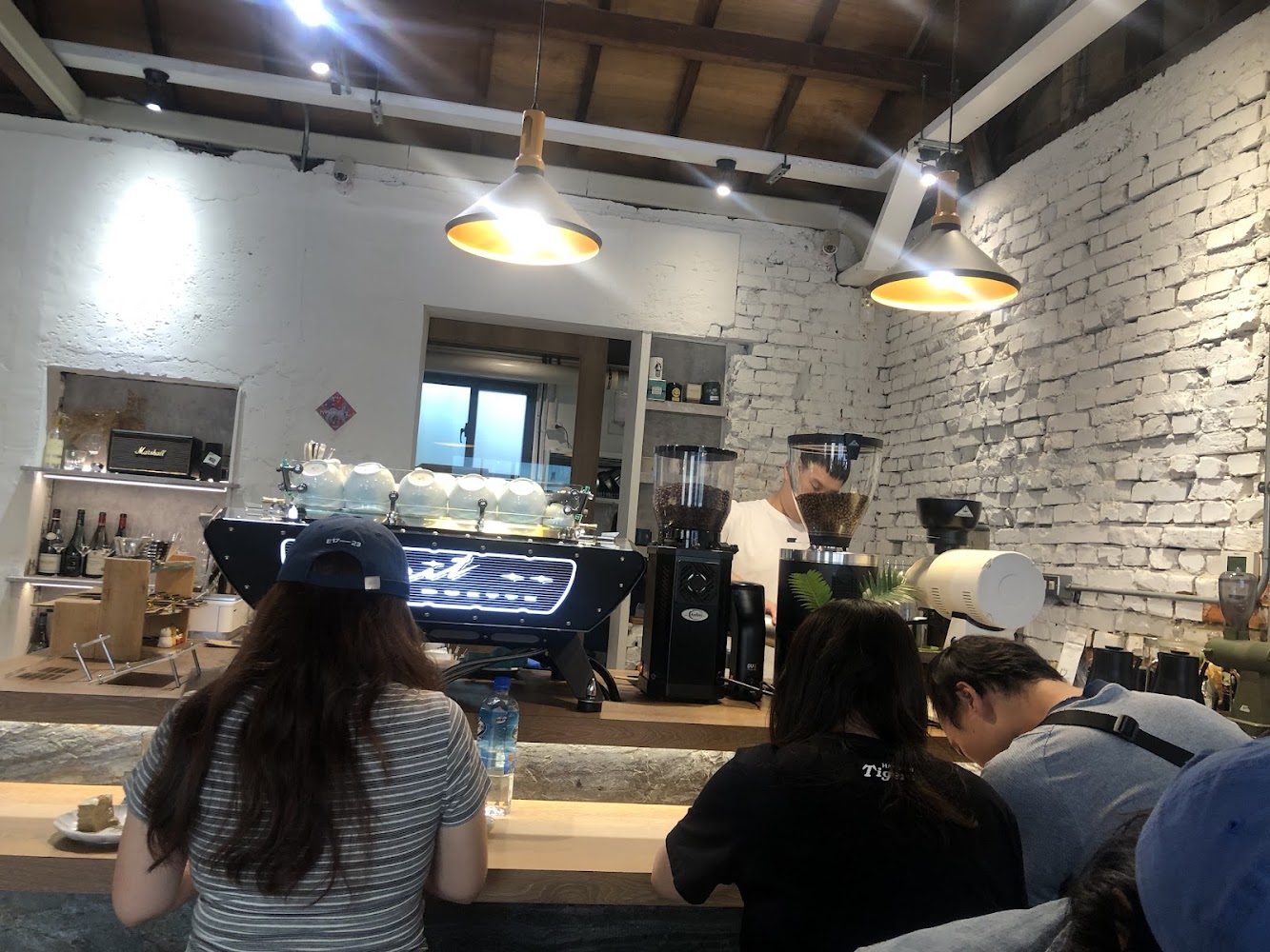 LIGAWA dessert哩嘎哇店內吧檯區有顧客與咖啡設備