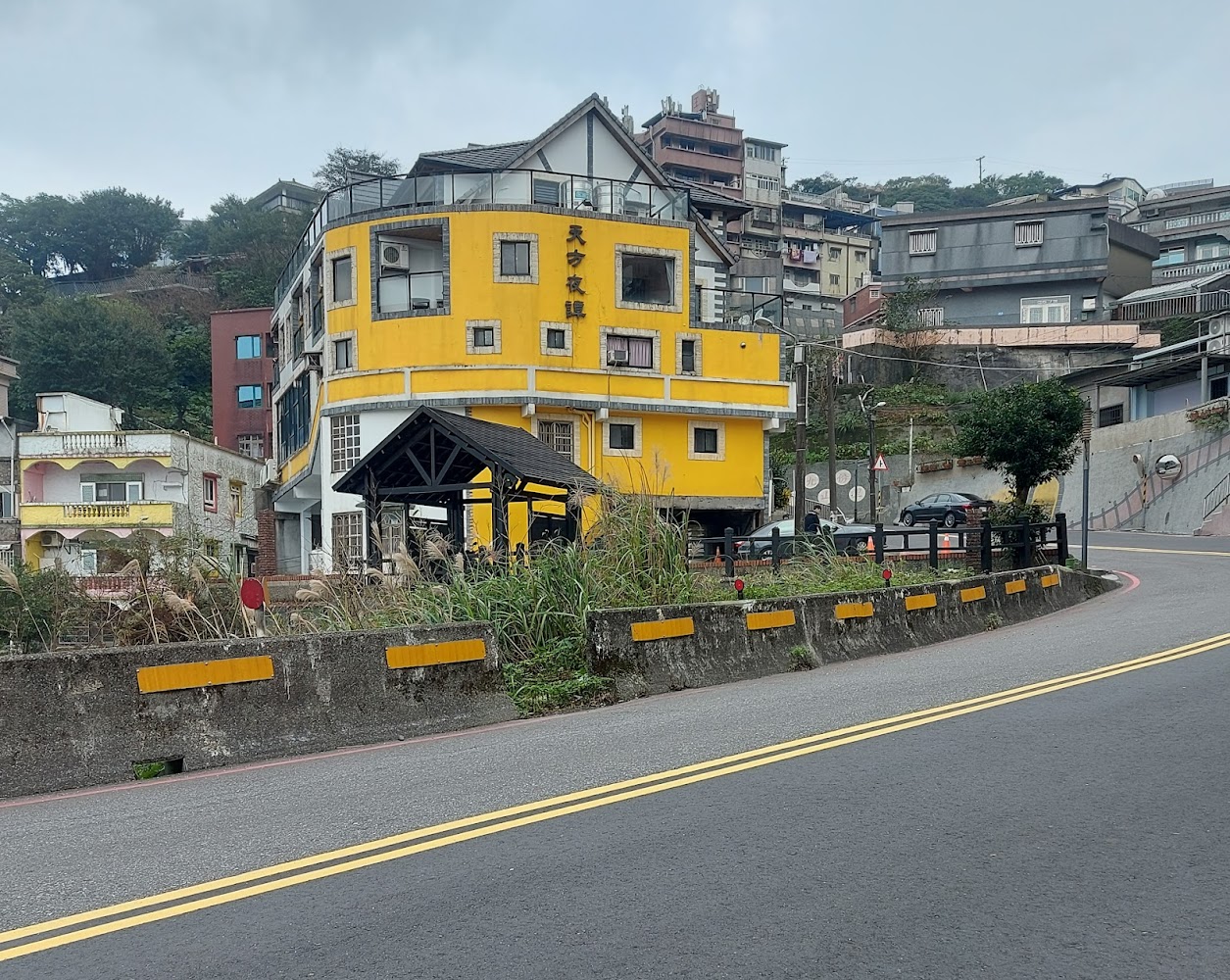 山坡彎道路旁的黃色多層建築