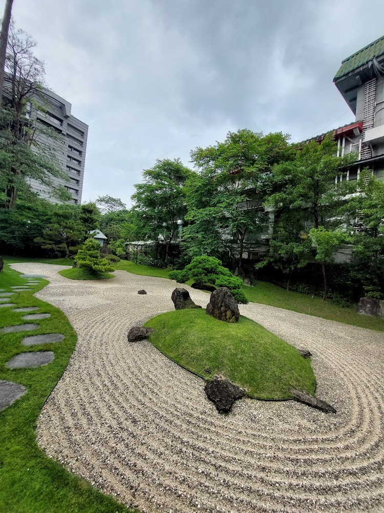 日式枯山水庭園，園內有整齊砂紋、岩石與圓形草地