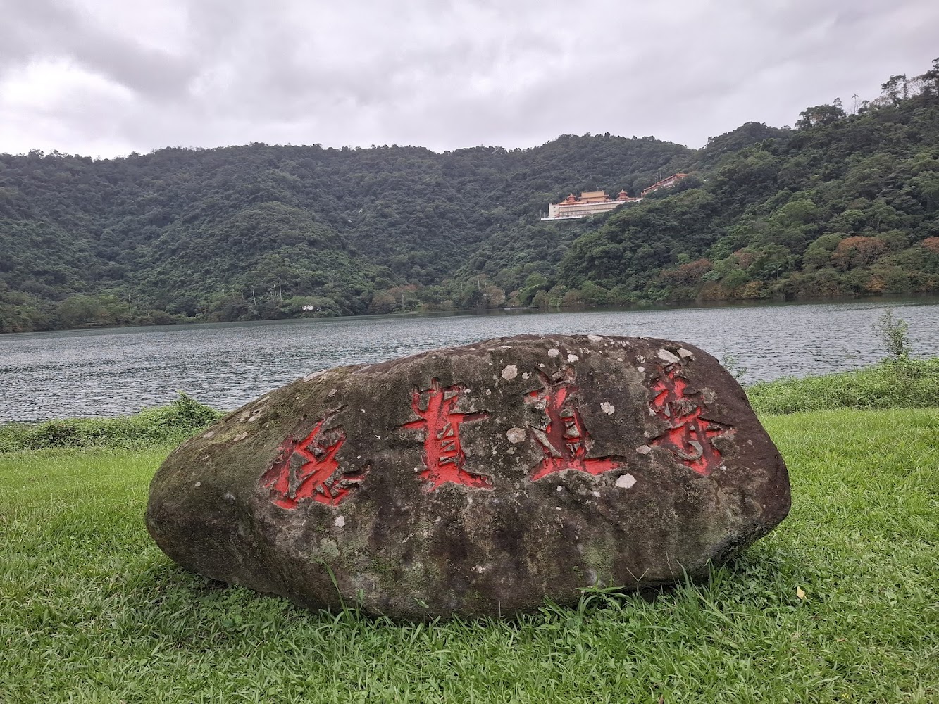刻有紅字巨石與湖景山景寺廟