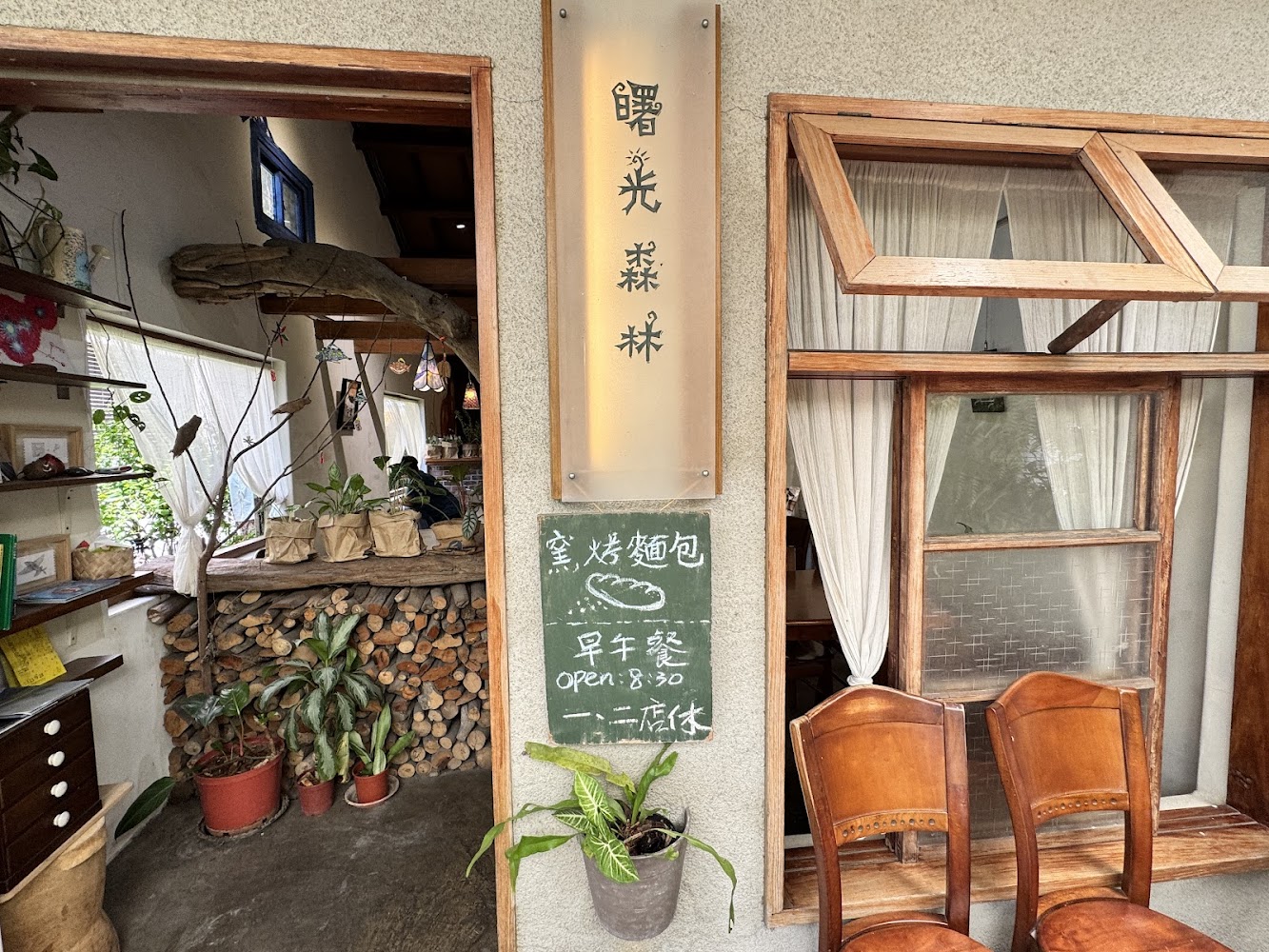 曙光森林門口外觀，木質窗框、植物與黑板招牌營造溫馨森林系氛圍