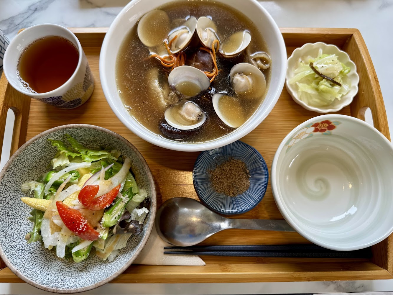 蛤蜊湯、沙拉與小菜組成的日式套餐細節