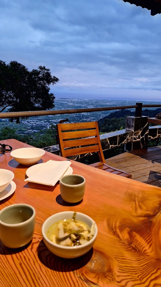 木桌上的碗杯茶杯與湯碗搭配戶外山景平原