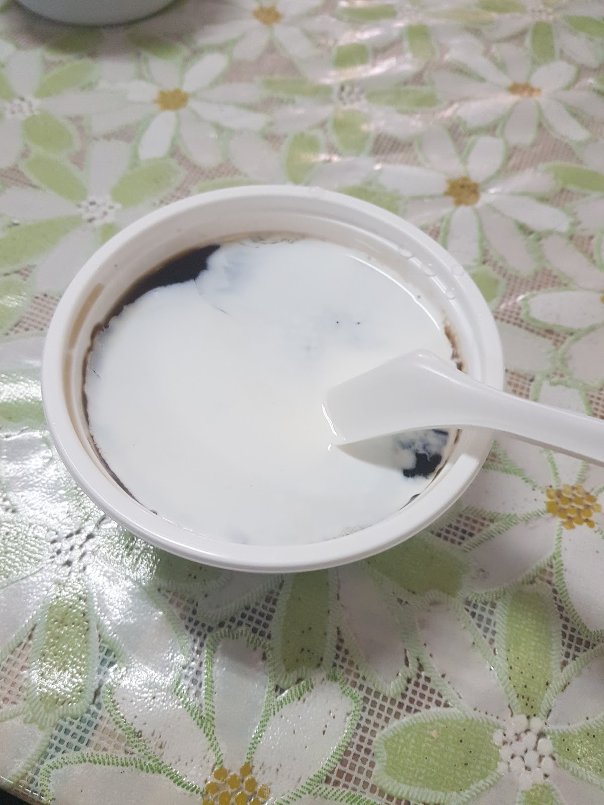 仙草凍淋上鮮奶，濃白牛奶覆蓋在深黑仙草上，黑白對比相當好看