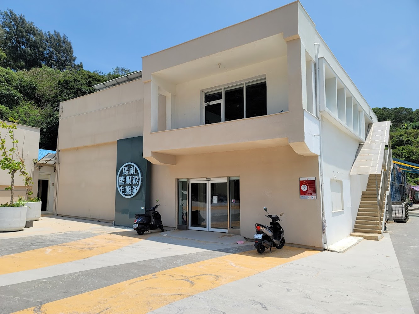 馬祖藍眼淚生態館側面建築與機車停放區