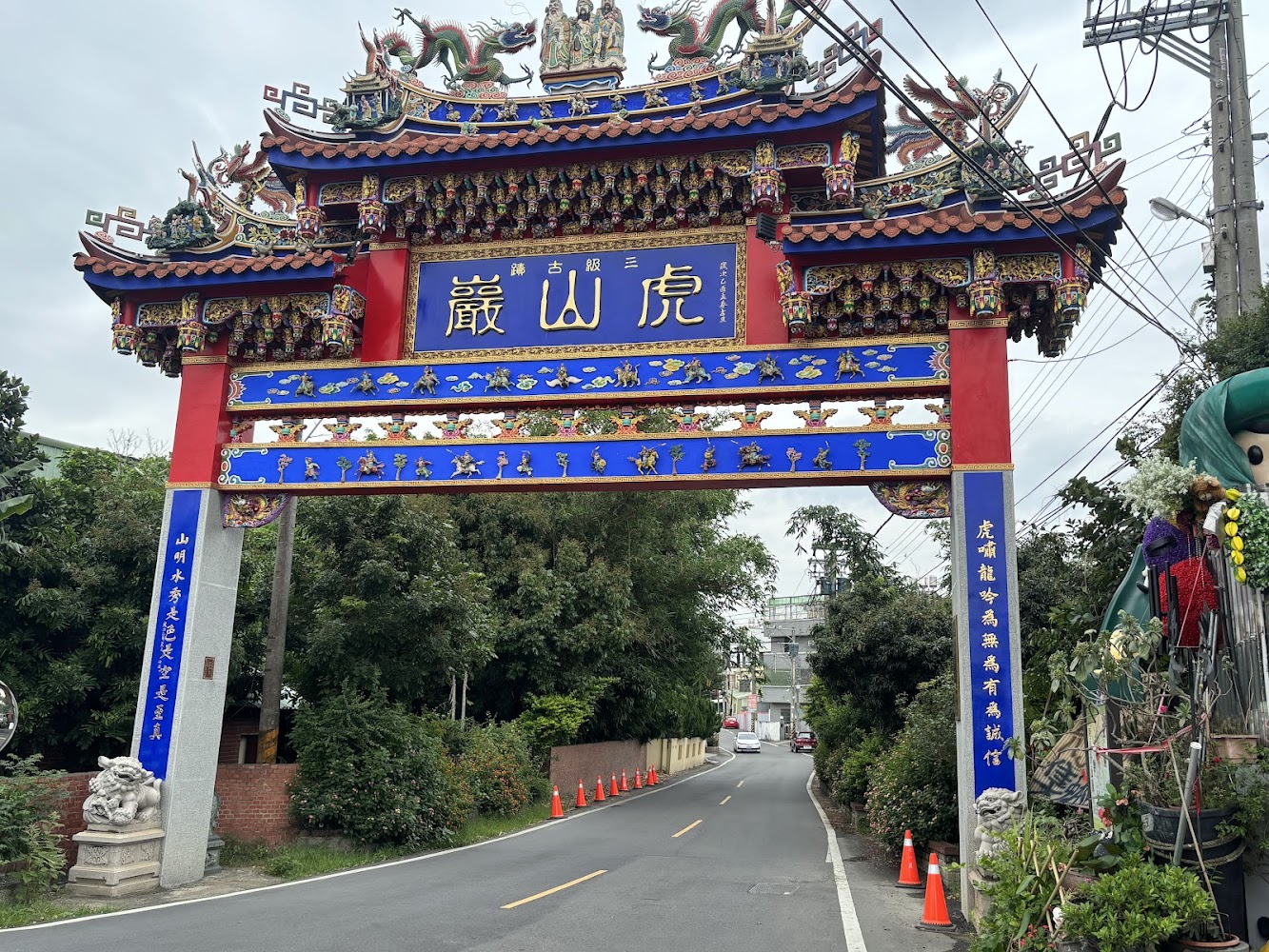 華麗的廟宇牌樓，上面有傳統的中式雕刻與虎山巖字樣