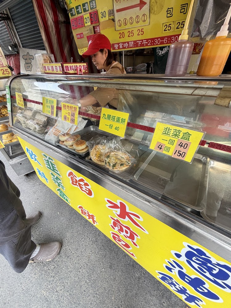 攤位前有菜單與工作人員準備餐點的畫面