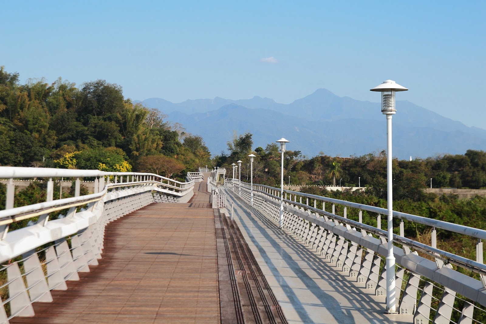 旗山溪地景主題步道橋木板步道遠景，白色護欄，路燈，遠山藍天