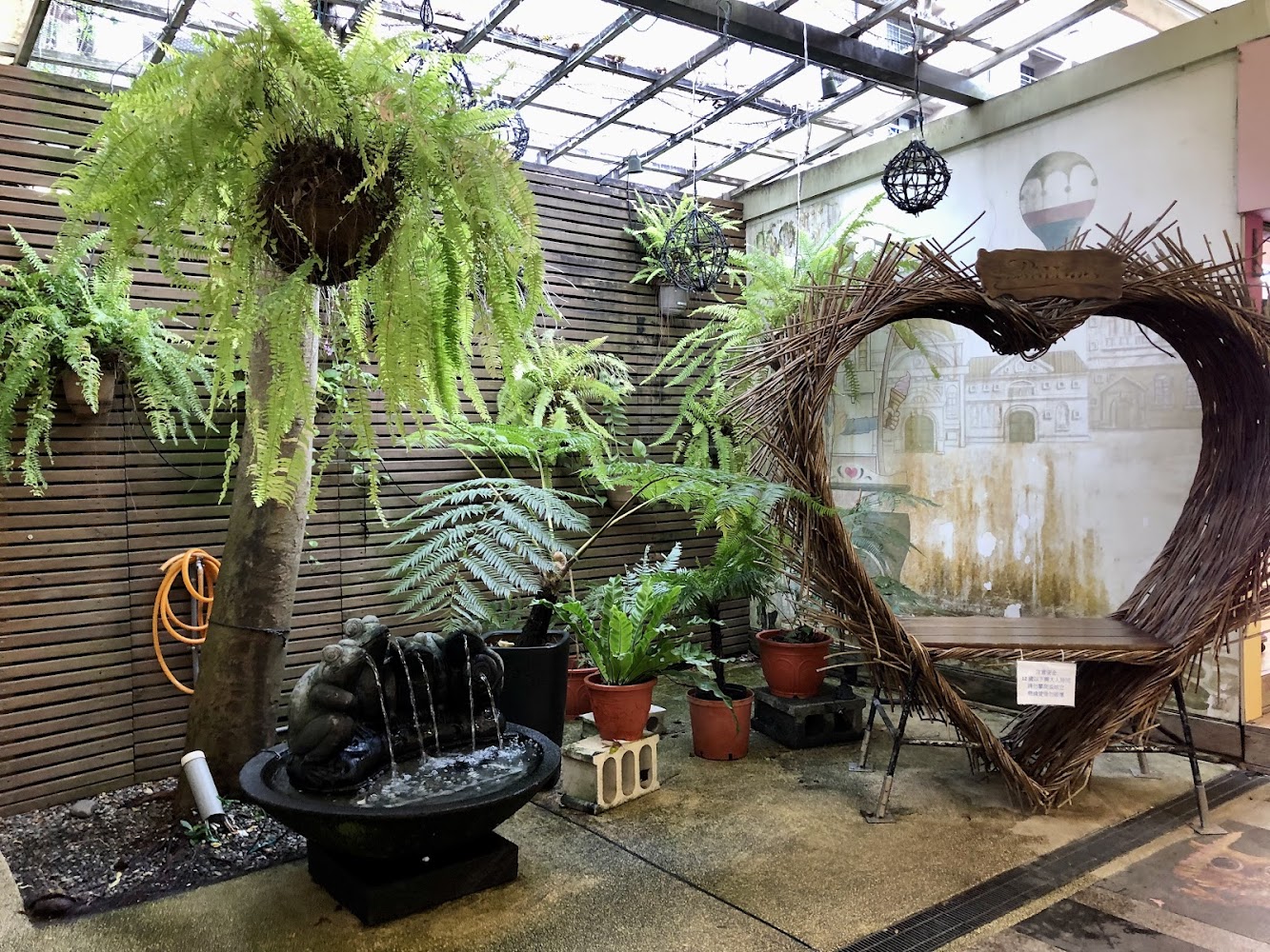 綠意盎然的小型室內花園與愛心藤編座椅