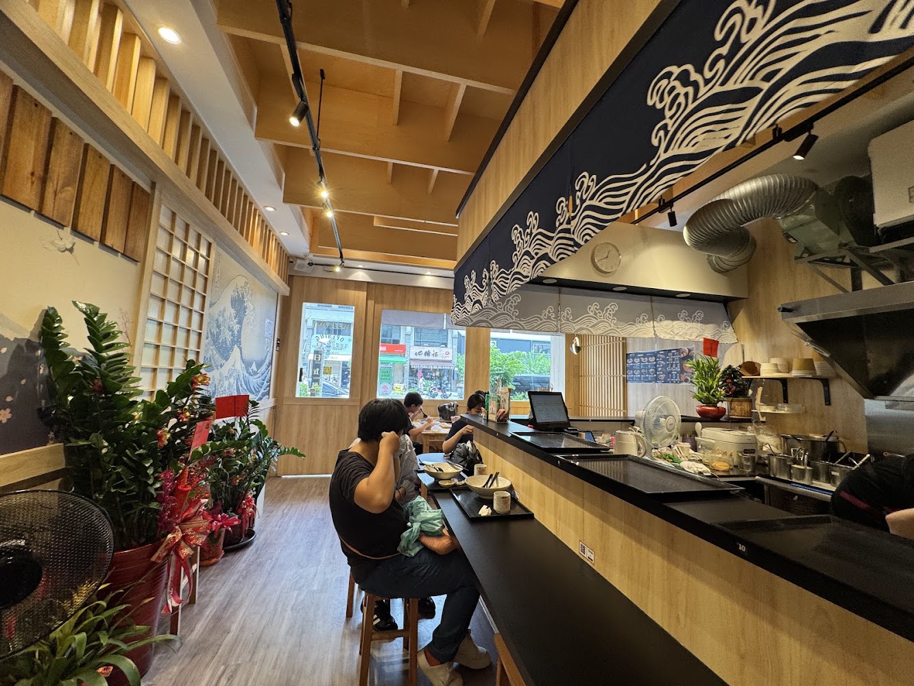 清流房日式拉麵店內木質裝潢、吧台與浮世繪風格牆面