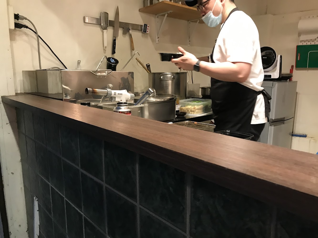 餐廳廚房區有廚師與整潔有序的料理台