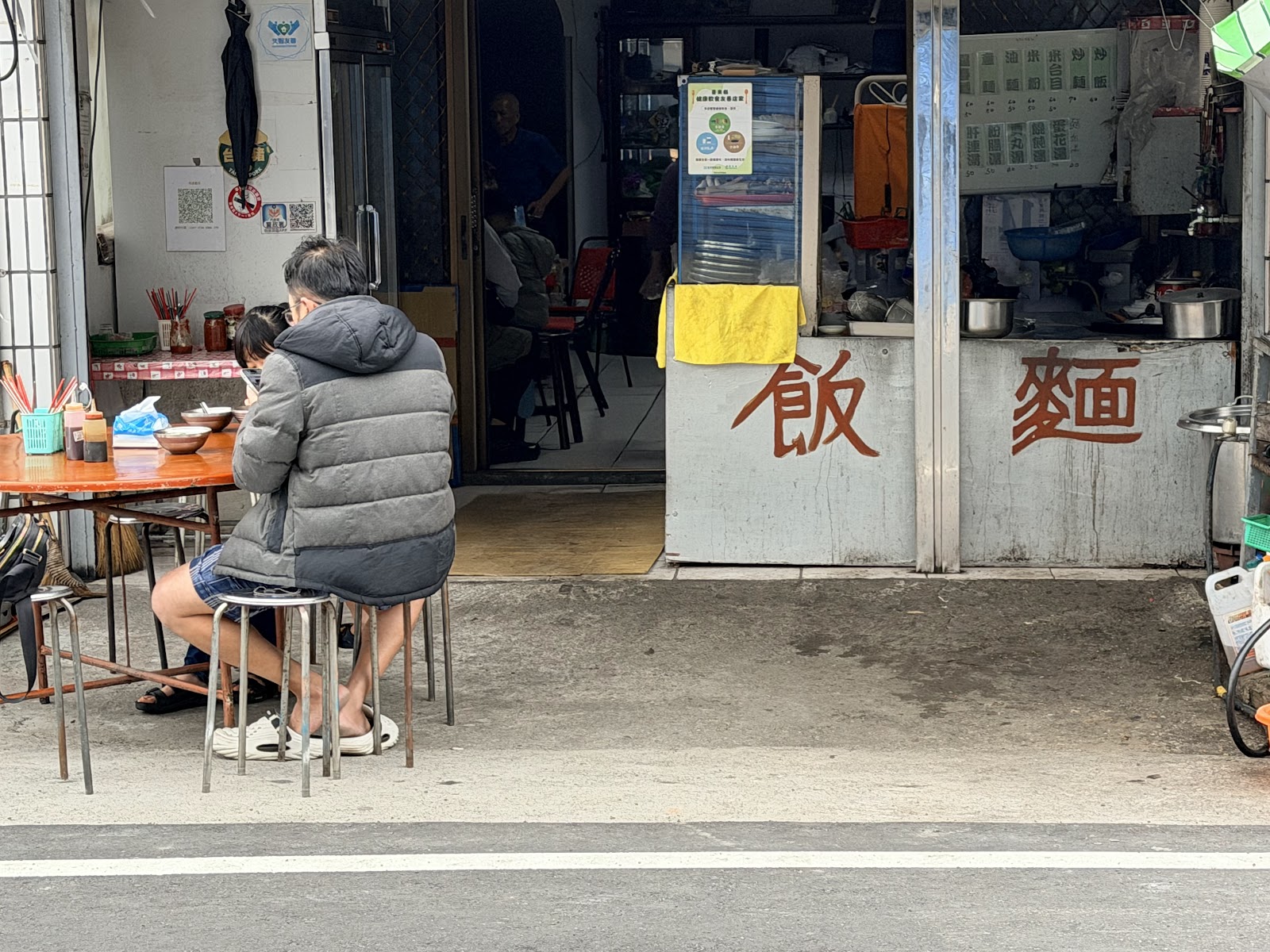 纏記東河包子店面入口，東河包子藍色LOGO醒目，前方展示傳統蒸籠