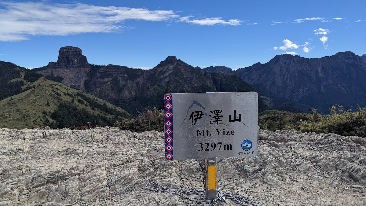 伊澤山山頂標示牌與背後高山景色