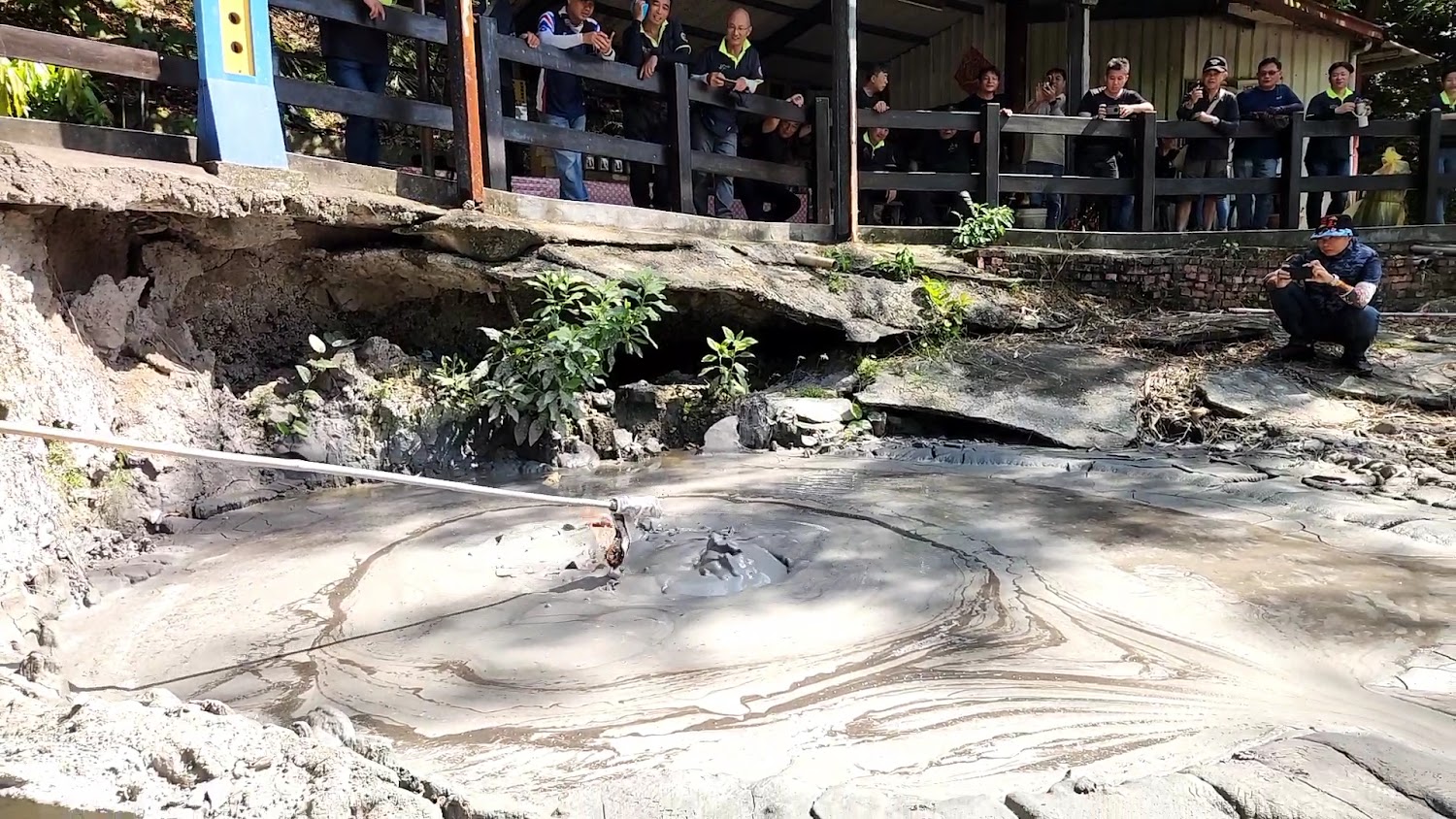 遊客圍觀泥漿池的畫面