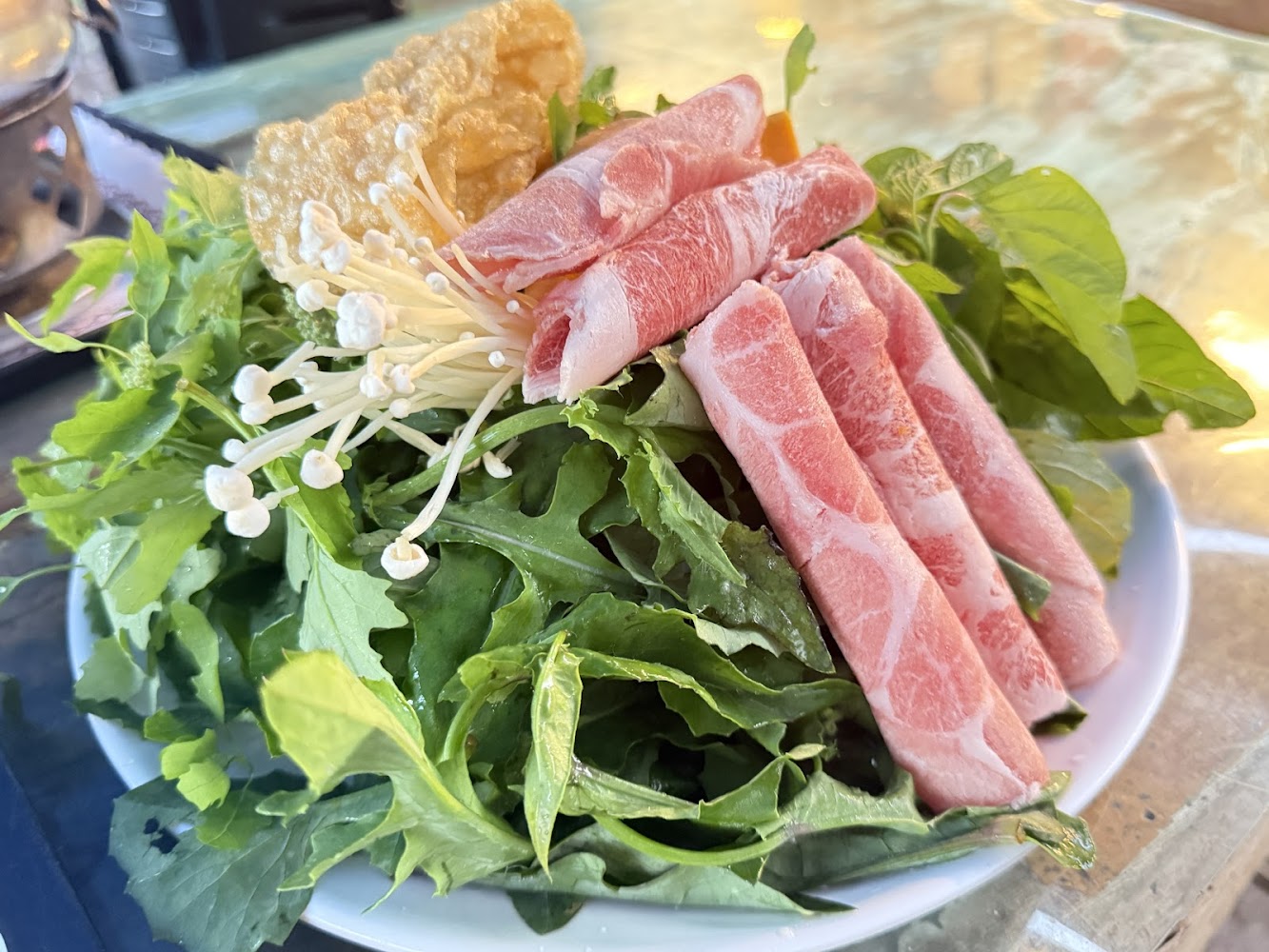 火鍋拼盤中的青菜金針菇與豬肉