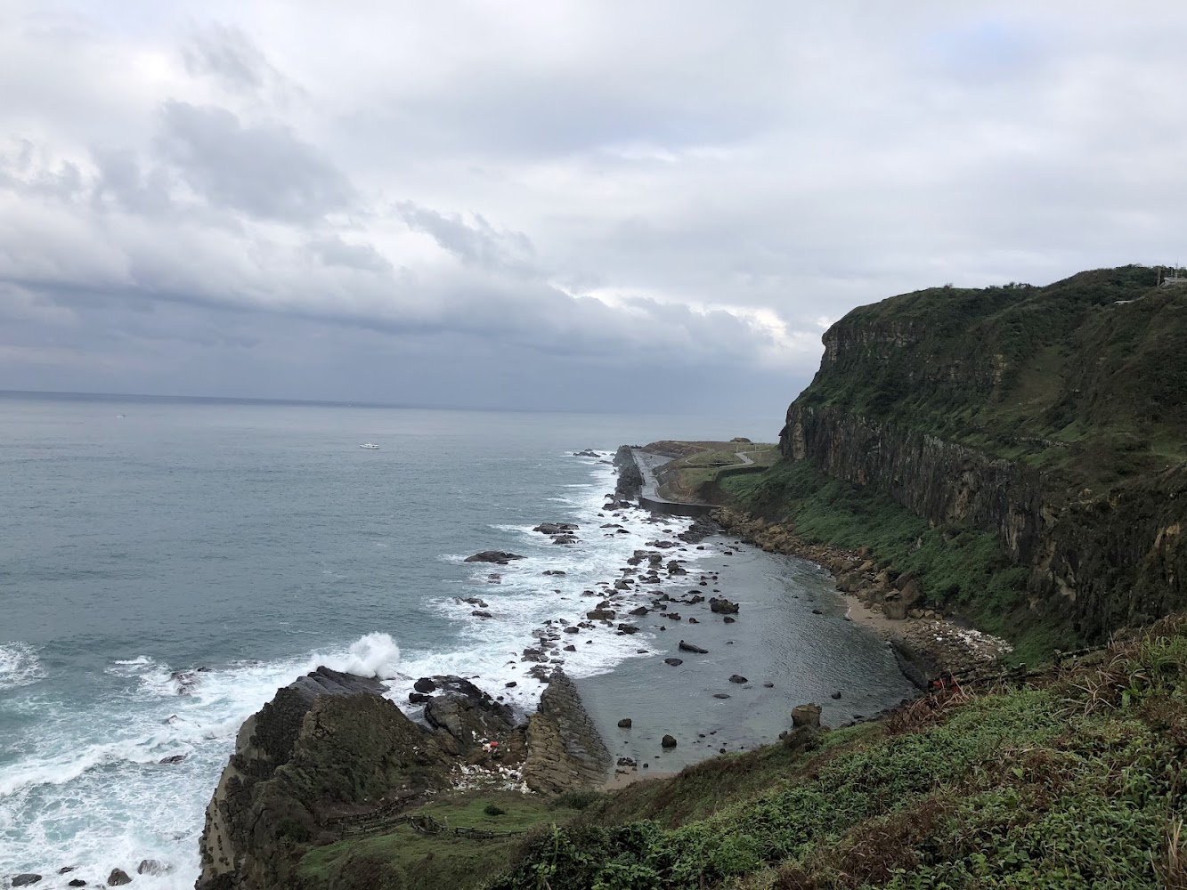 高聳懸崖與礁石海岸線，海浪拍打岸邊