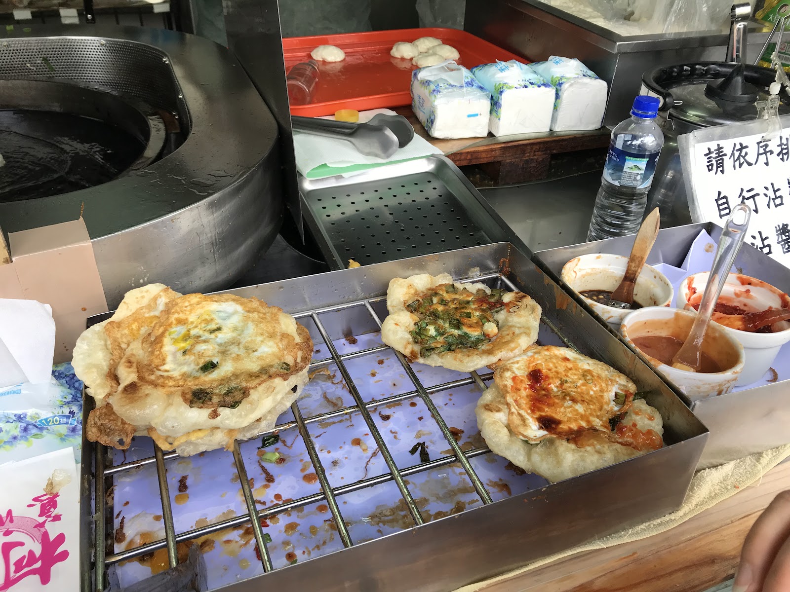 柯氏蔥油餅，烤架上三片蔥油餅加蛋，金黃酥脆