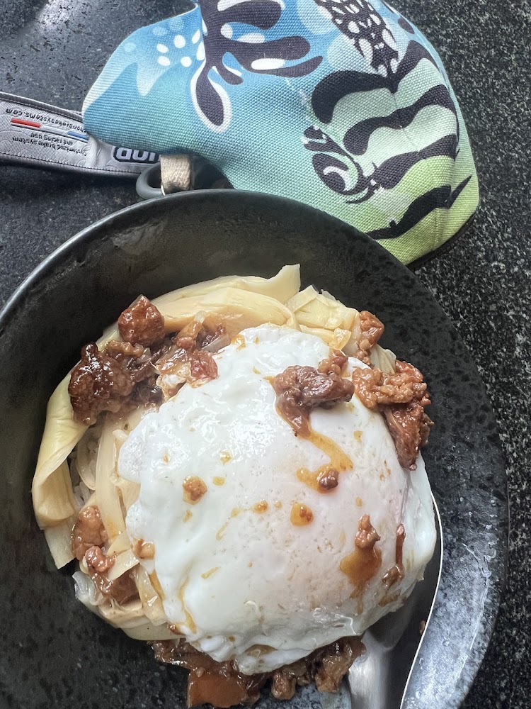 黑色碗裝美食，有荷包蛋、滷肉及筍乾等配料