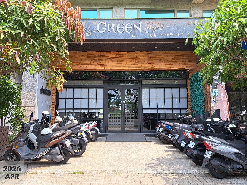 這張圖片主要顯示一家名為GREEN的店面，店門前有許多機車停放，兩側有綠色植物點綴，整體環境充滿自然和現代感。