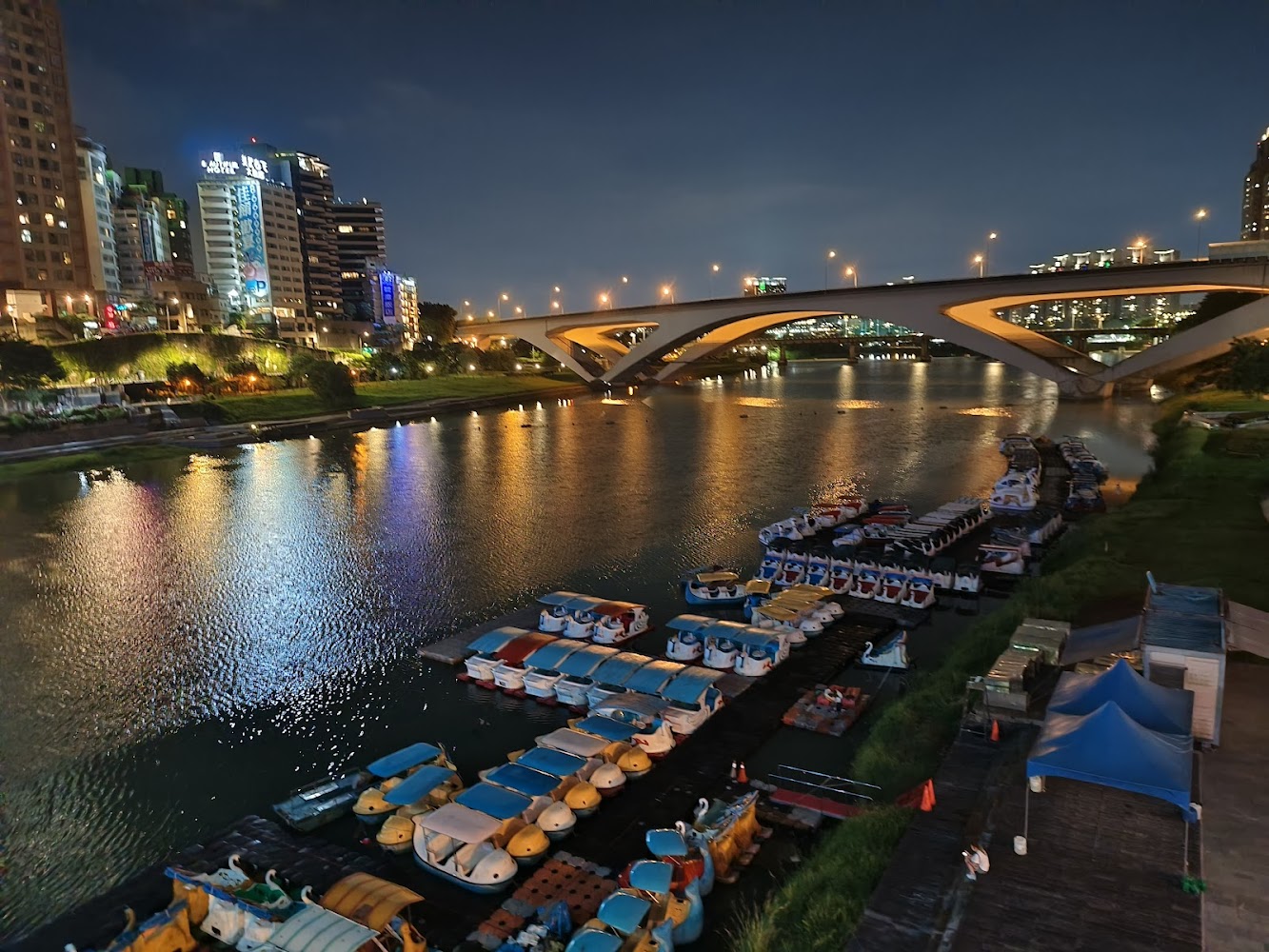 夜間碼頭停靠天鵝船與城市燈火