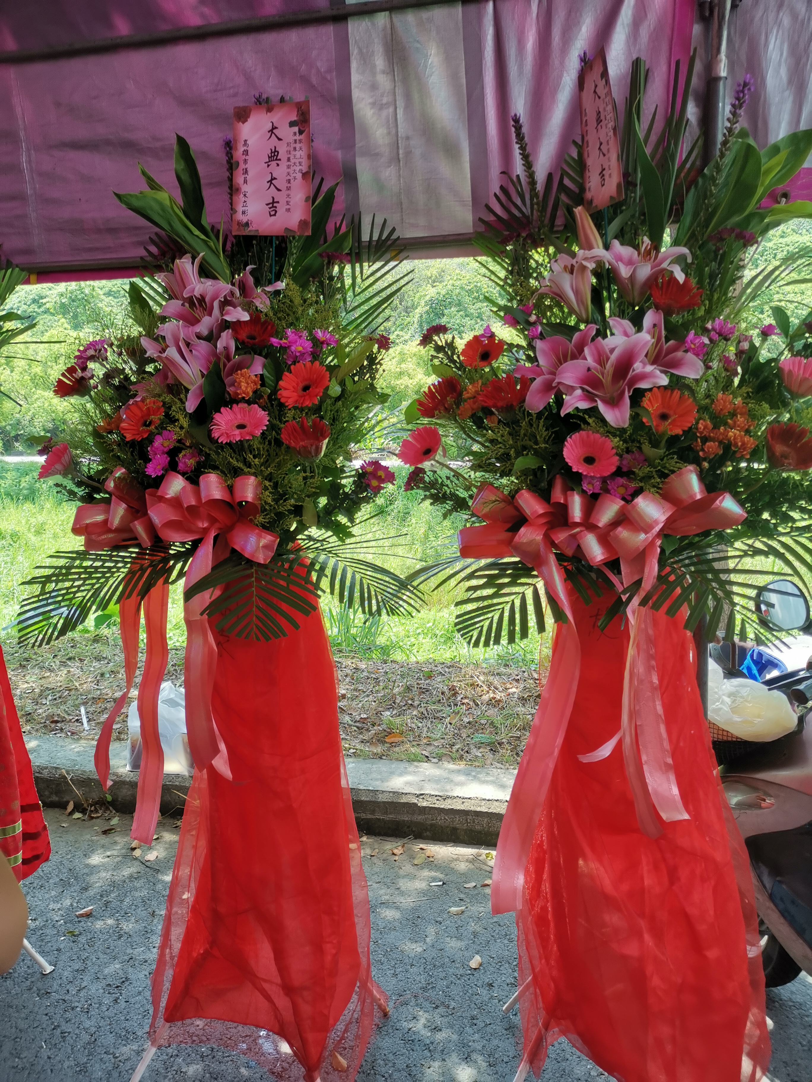 兩個大型落地開幕花籃，裝飾鮮花與紅色緞帶