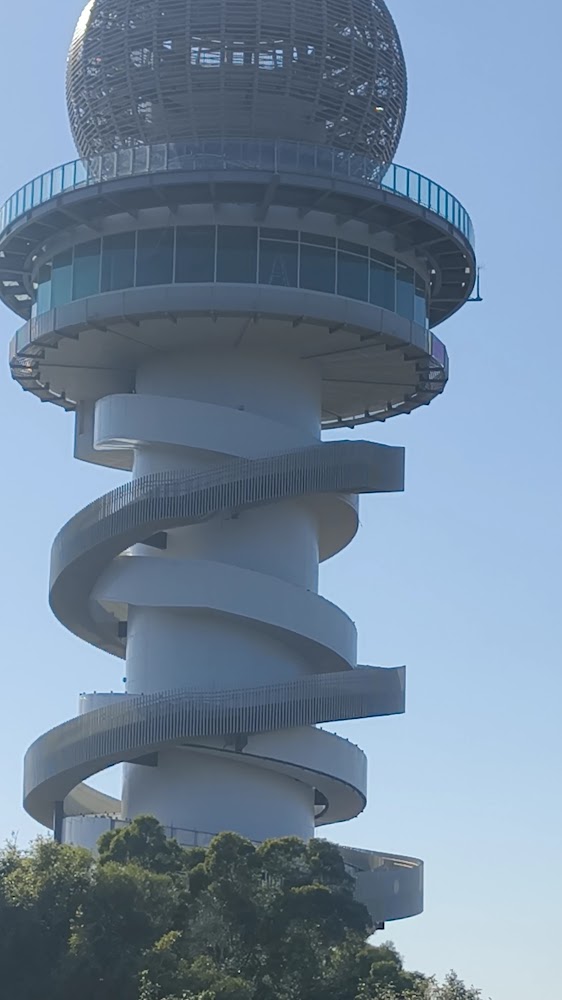 一座高塔，塔身有螺旋步道繞行而上，頂部有球狀結構與觀景平台，整體建築造型現代新穎。