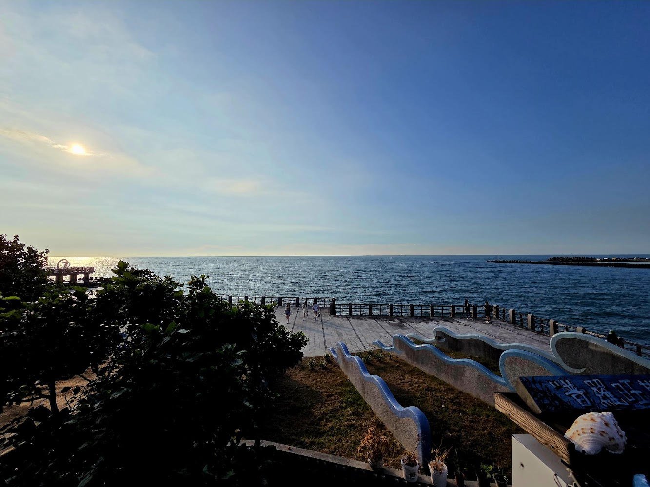 寬闊海景有夕陽觀海平台波浪欄杆和貝殼裝置