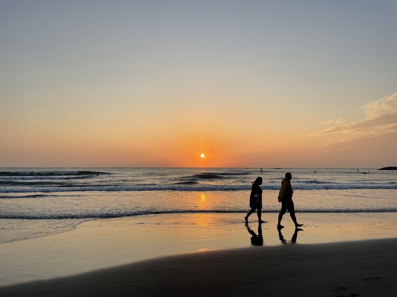 夕陽時分兩人在漁光島沙灘散步，氣氛浪漫寧靜