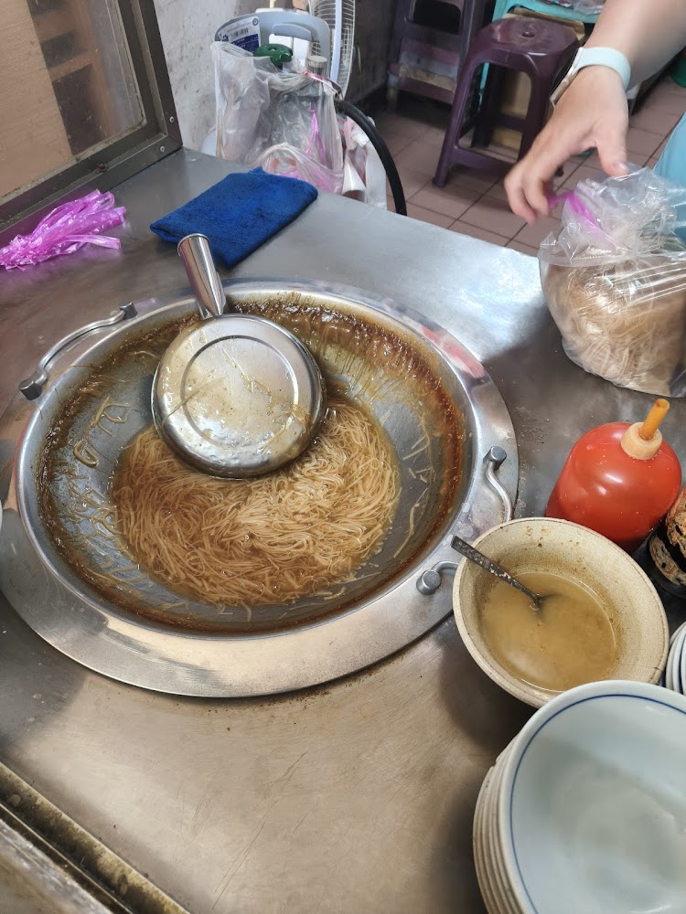 攤位正在將麵線裝袋，旁邊有調味料與碗盤