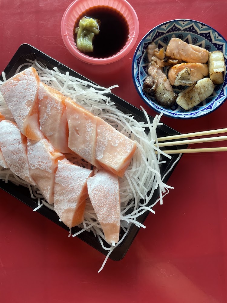 鮭魚生魚片搭配醬油與炙燒魚片的一桌海鮮料理