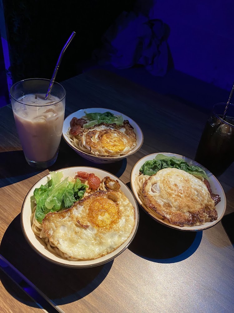 三碗拌麵搭配煎蛋與飲料，餐桌氣氛溫馨