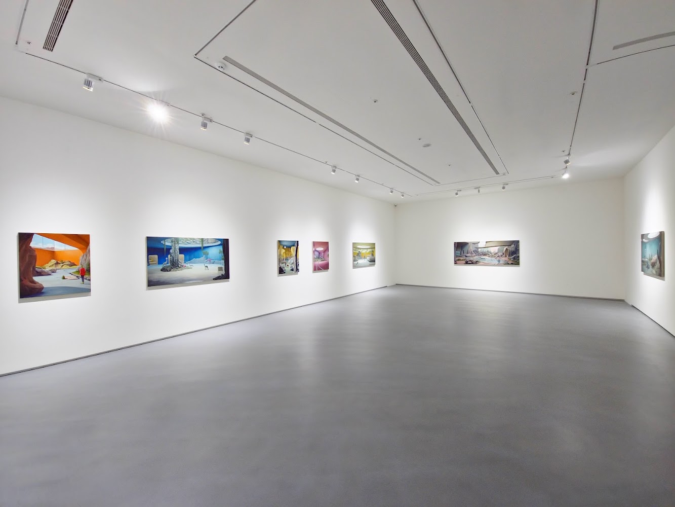 館內寬敞展廳，牆面掛有多幅風格鮮明的畫作