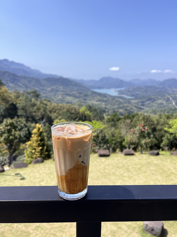 欄杆上的冰拿鐵與遼闊山景湖泊背景