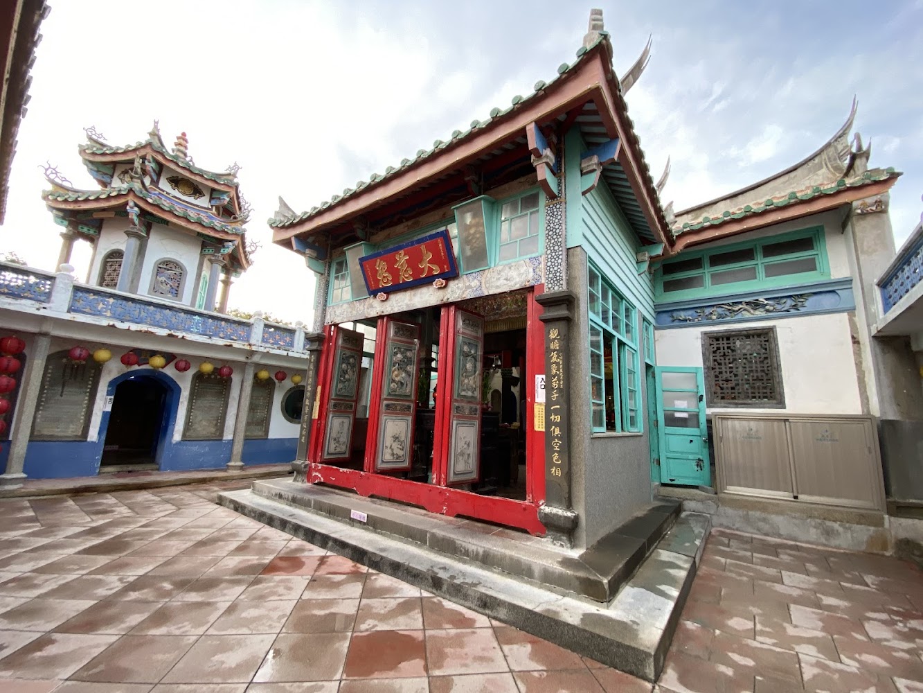 綠瓦紅門的傳統廟宇建築，帶有古色古香氛圍。