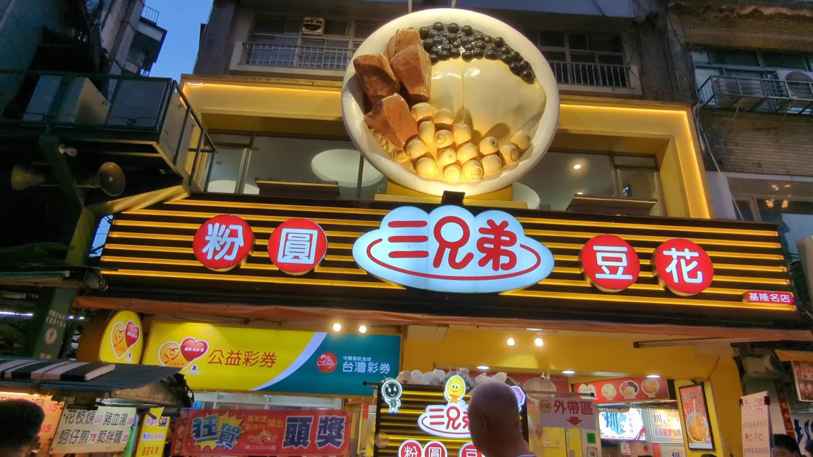 基隆三兄弟粉圓豆花名店，黃色大招牌夜晚燈光閃耀