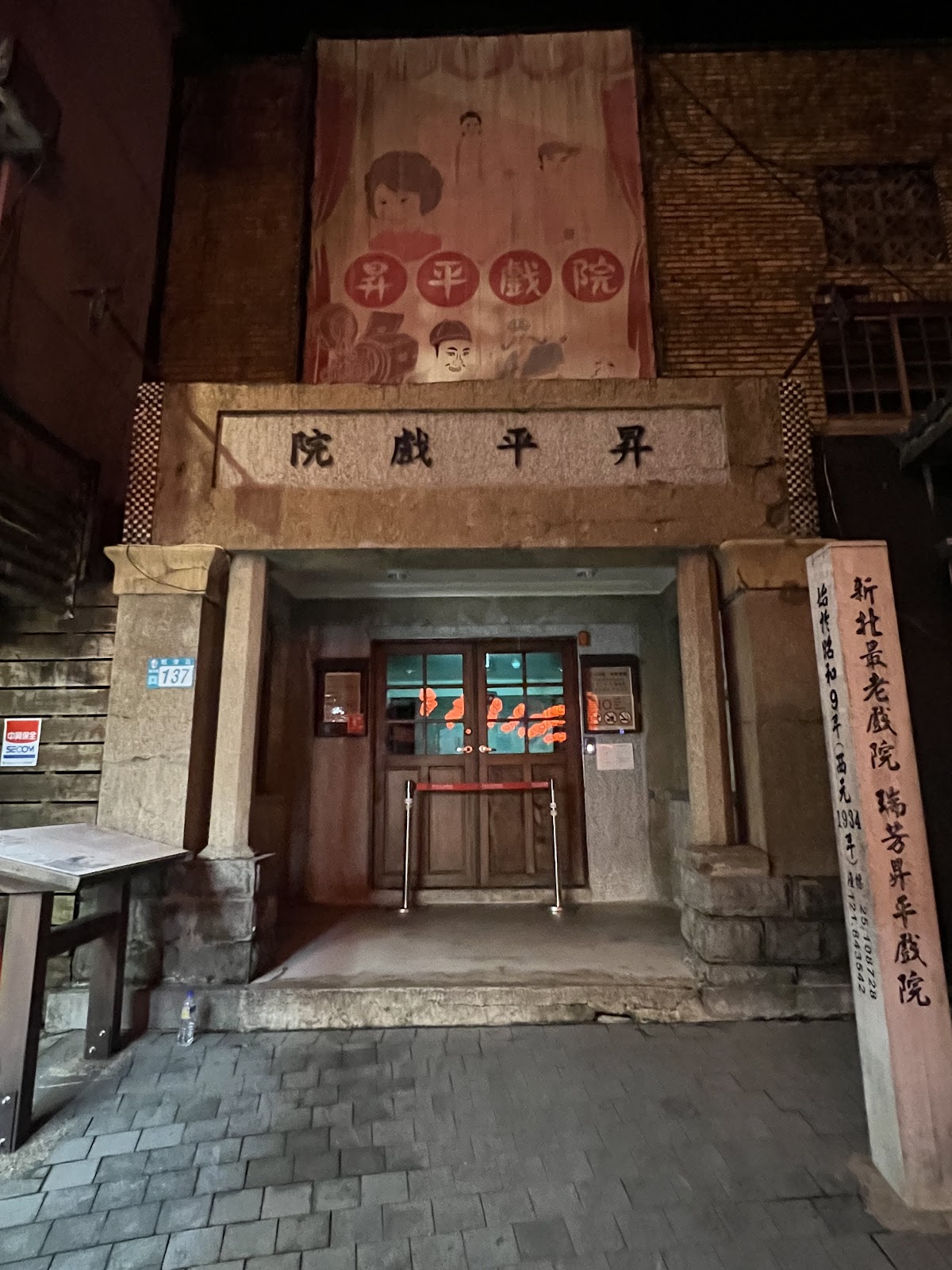 九份昇平戲院夜景，磚牆建築正門，懷舊海報，夜間燈光映照
