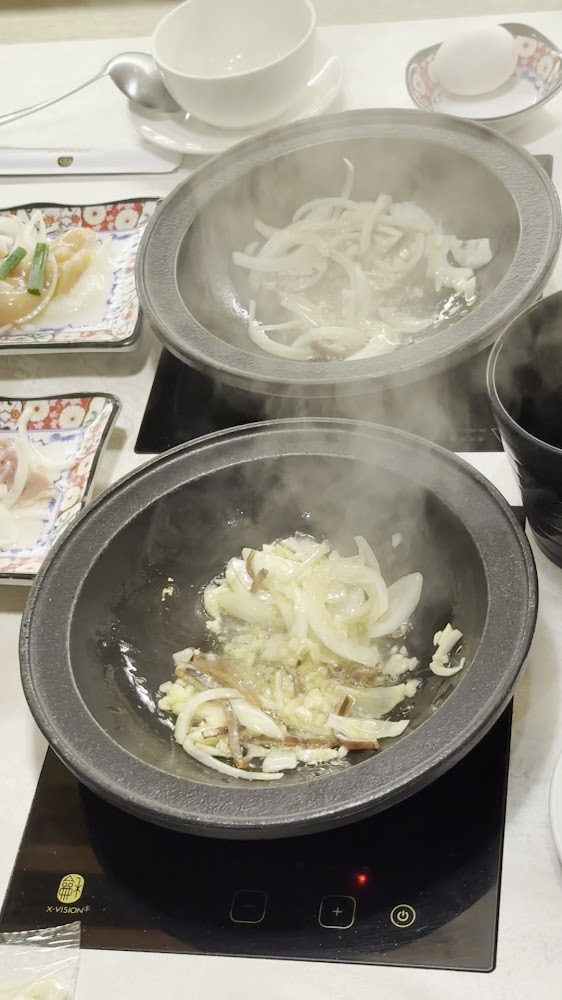石鍋內爆炒洋蔥與蒜頭的石頭火鍋料理情境