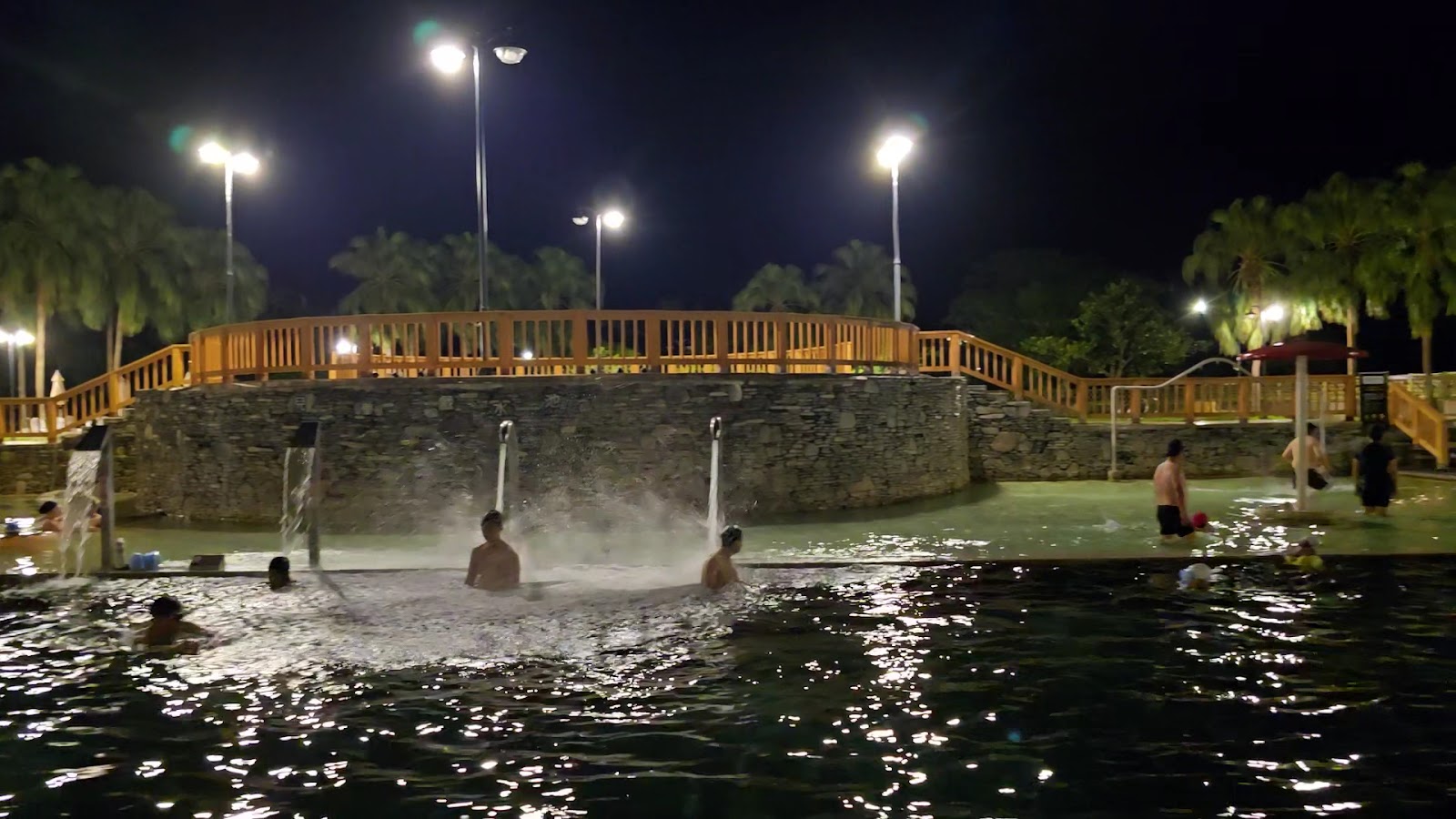 東遊季溫泉渡假村夜間溫泉池，燈光倒映水面，夜色中格外靜謐浪漫