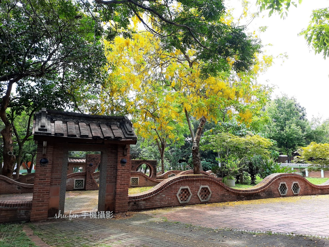 紅磚拱門與波浪磚牆的園林景觀