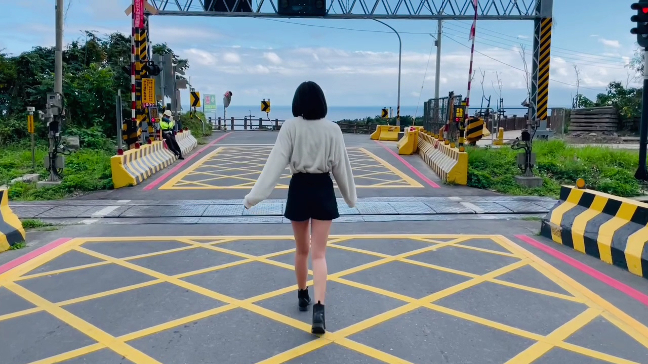 背對鏡頭的旅人走在太麻里平交道旁